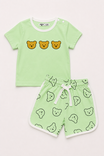 A two-piece baby clothing set featuring a light green short-sleeve t-shirt with three yellow bear faces on the chest, and matching light green shorts with a white drawstring and an all-over bear face pattern.