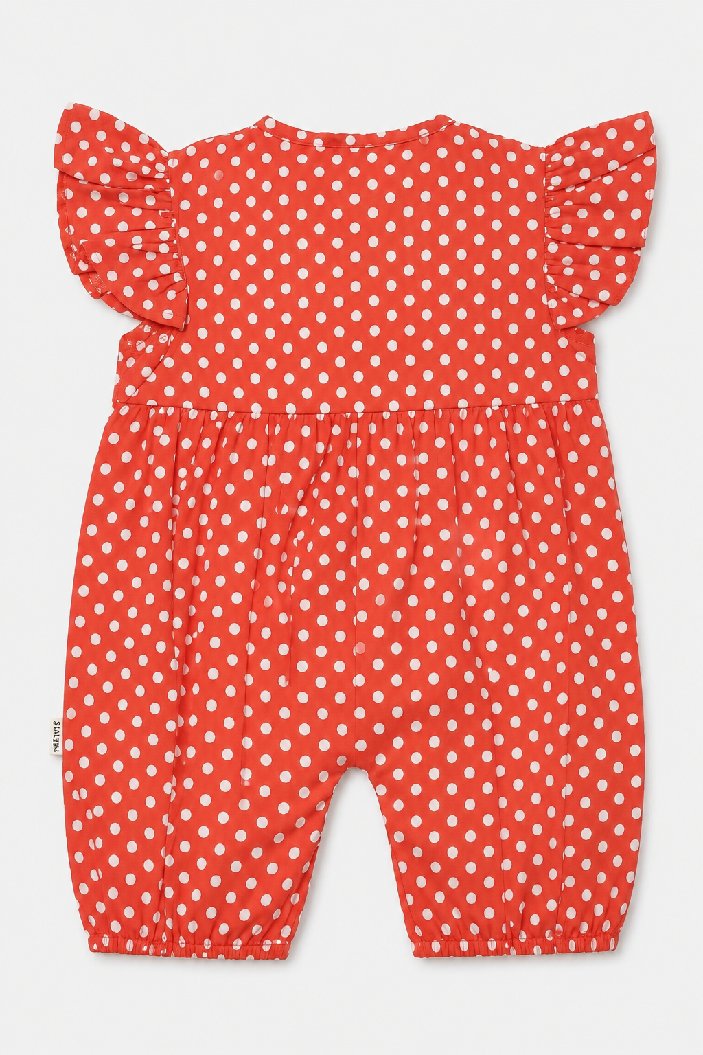 A baby romper in red with a white polka dot pattern, featuring ruffled shoulder straps and a gathered waist, shown against a light gray background.